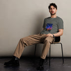 Man sitting on a chair wearing a graphic sunset t-shirt against a plain background