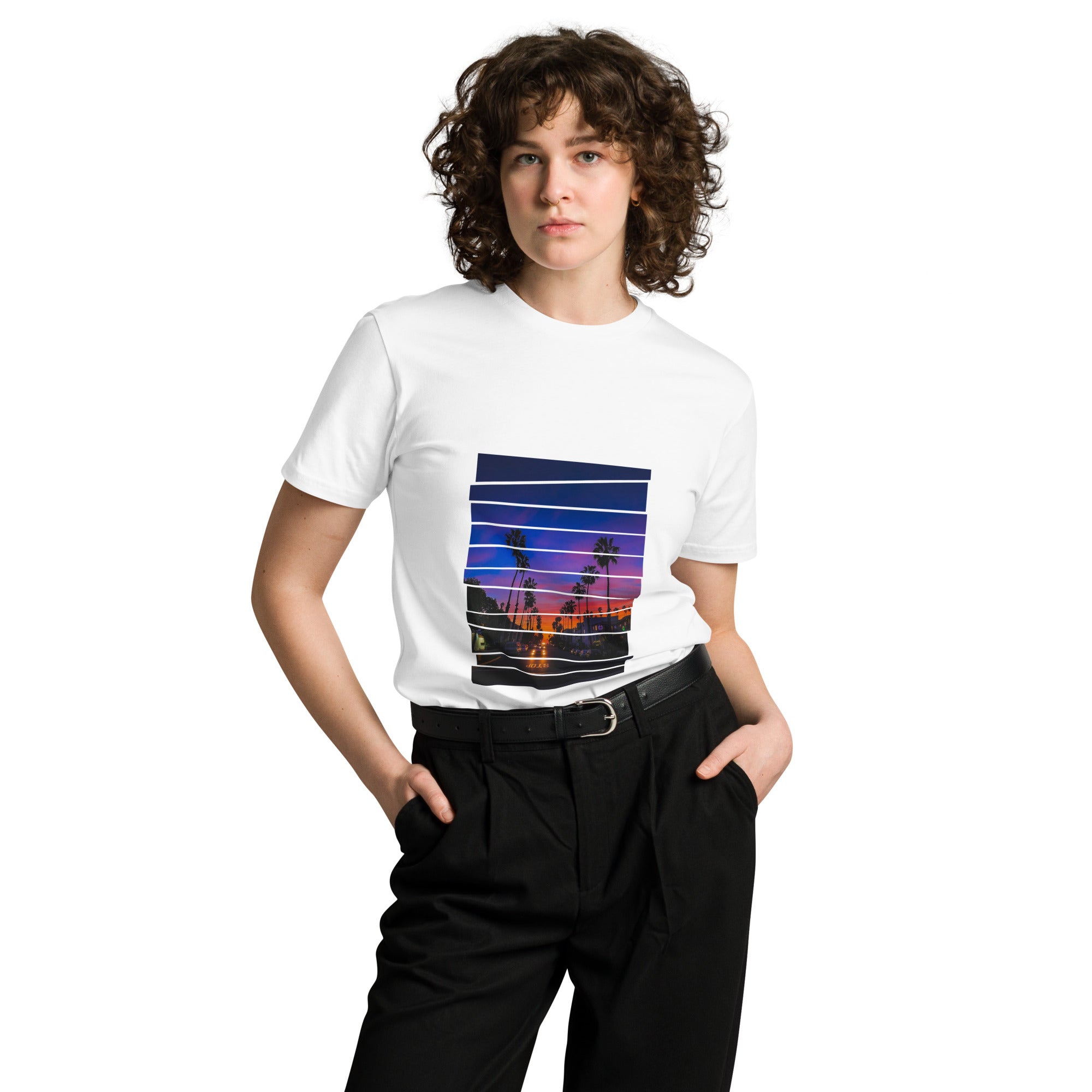 Woman wearing a white graphic sunset t-shirt with a colorful graphic design on a white background