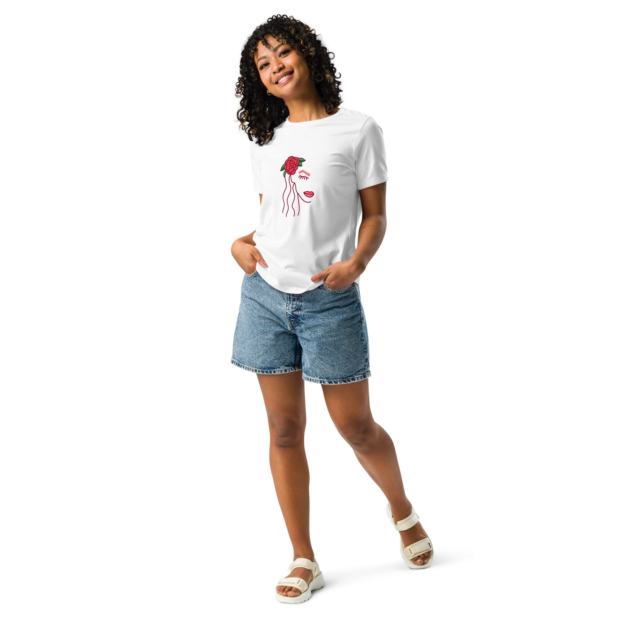 Woman wearing a white t-shirt with a woman's face graphic design and denim shorts on a white background